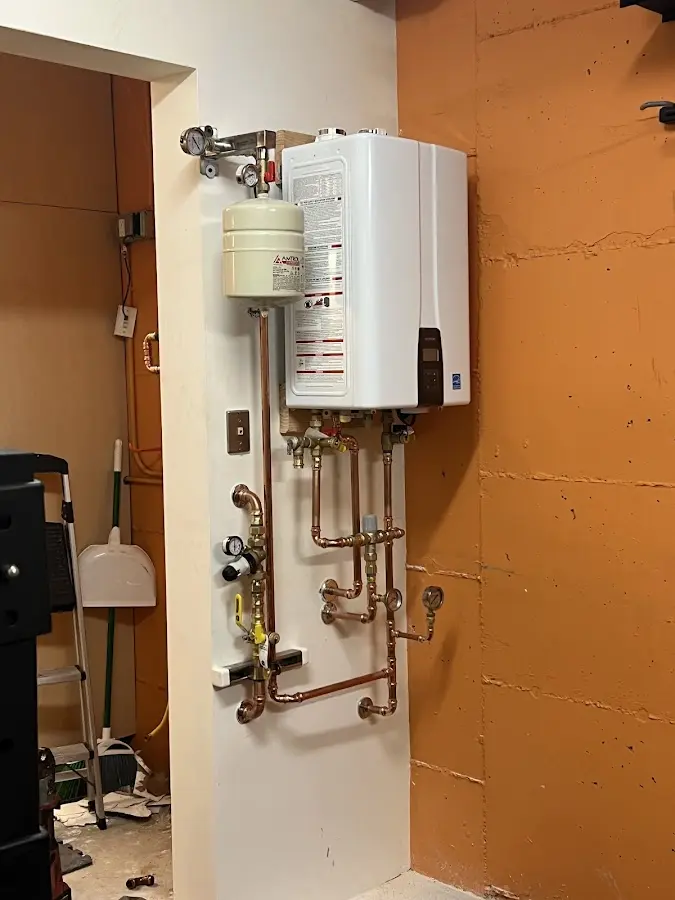 Plumbing technician inspecting water heater connections in Garwood